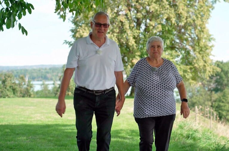 Gabi und Röbi aus Bauer ledig sucht gehen Hand in Hand über eine Wiese
